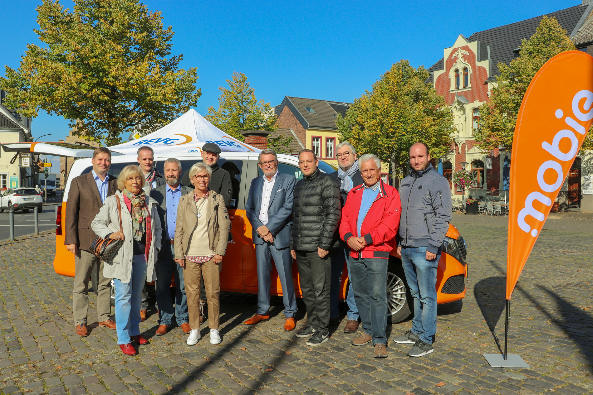 Marktplatz in Erftstadt Lechenich. Vor dem mobie Fahrzeug stehen Vertreter der REVG (Martin Gawrisch und Walter Reinarz) und der Stadt Erftstadt.